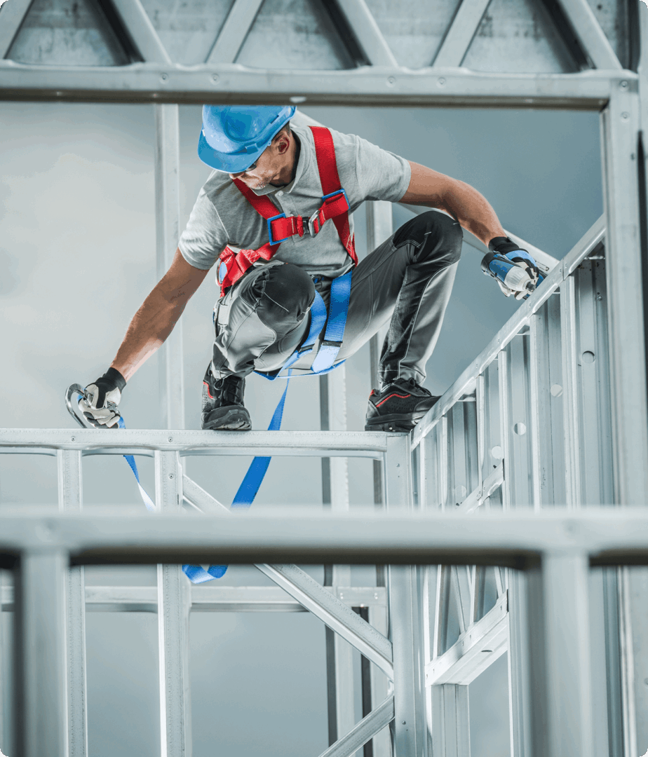Construction worker assembling metal framework structure.