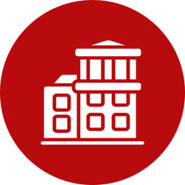 White buildings icon on red circle background.